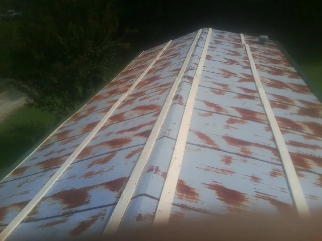 Rusted metal roof panels with new wood purlins before replacement — Storm Damage Roof Repair in Salisbury by Roofing Brothers
